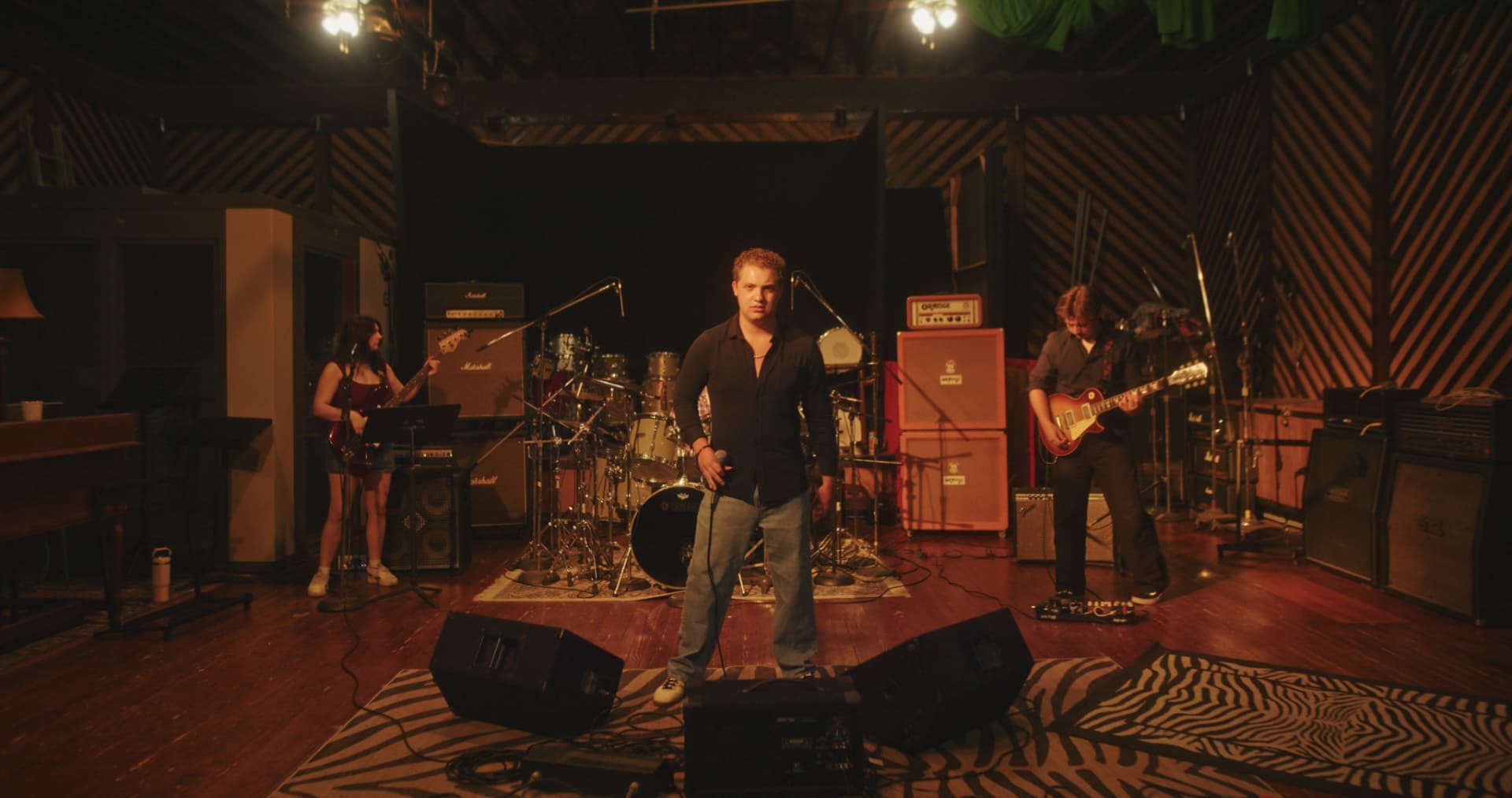 Davey J standing center with the full band, amps and drums behind