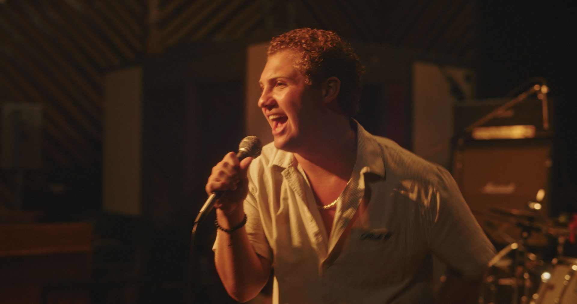 Davey J singing into a microphone in the studio